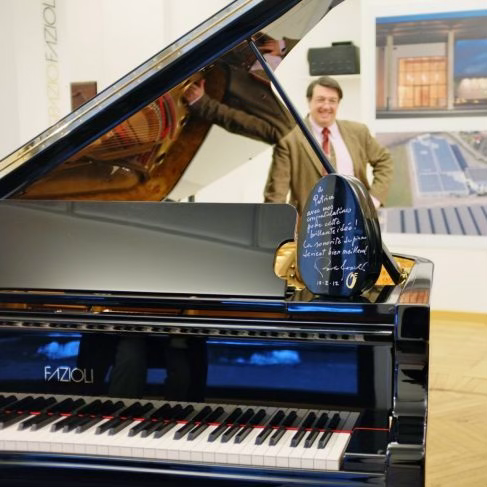 OVAL Sound System dédicacé devant un piano Fazioli